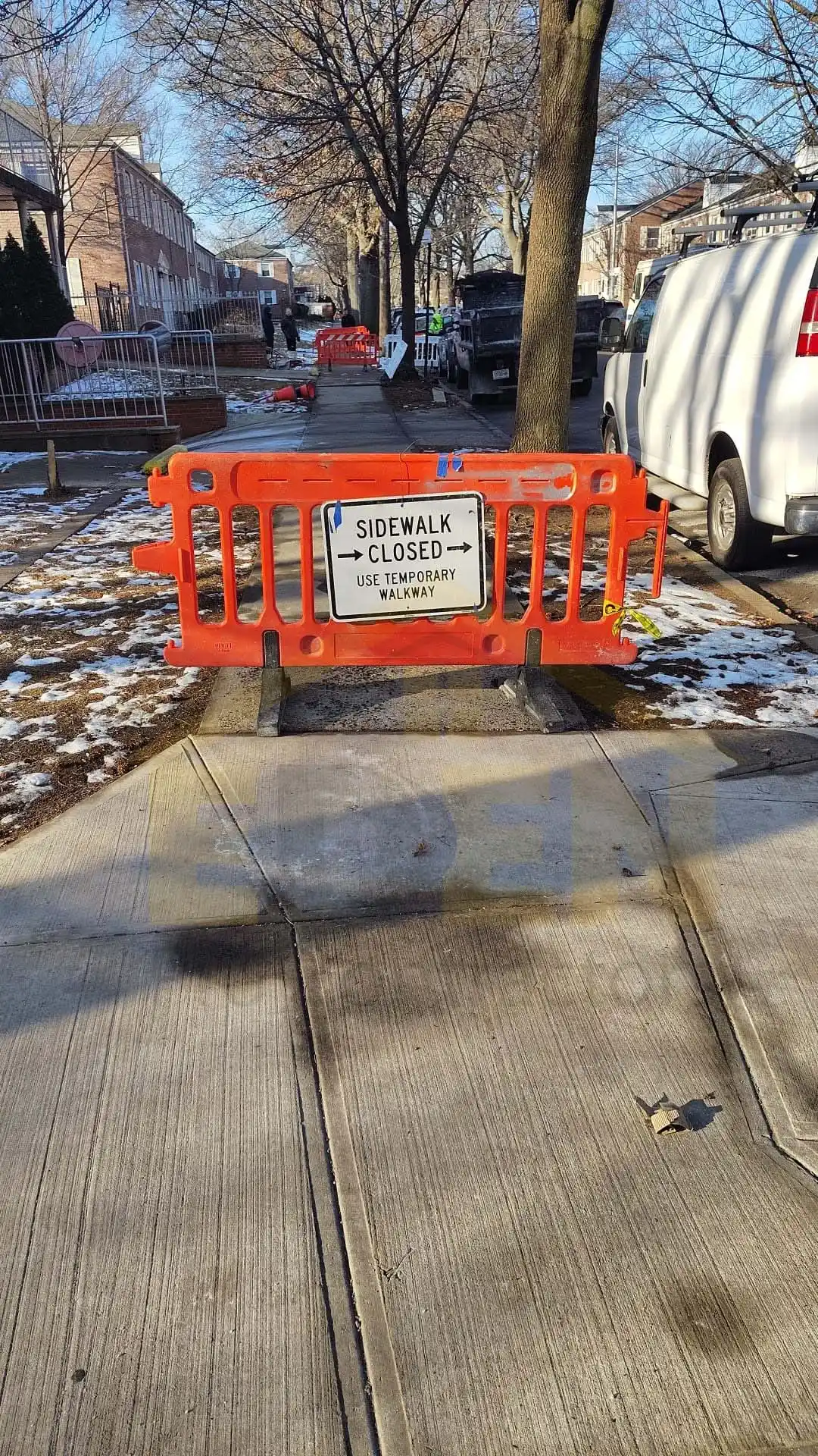NYC homeowner applying salt on a concrete sidewalk to prevent winter ice buildup.